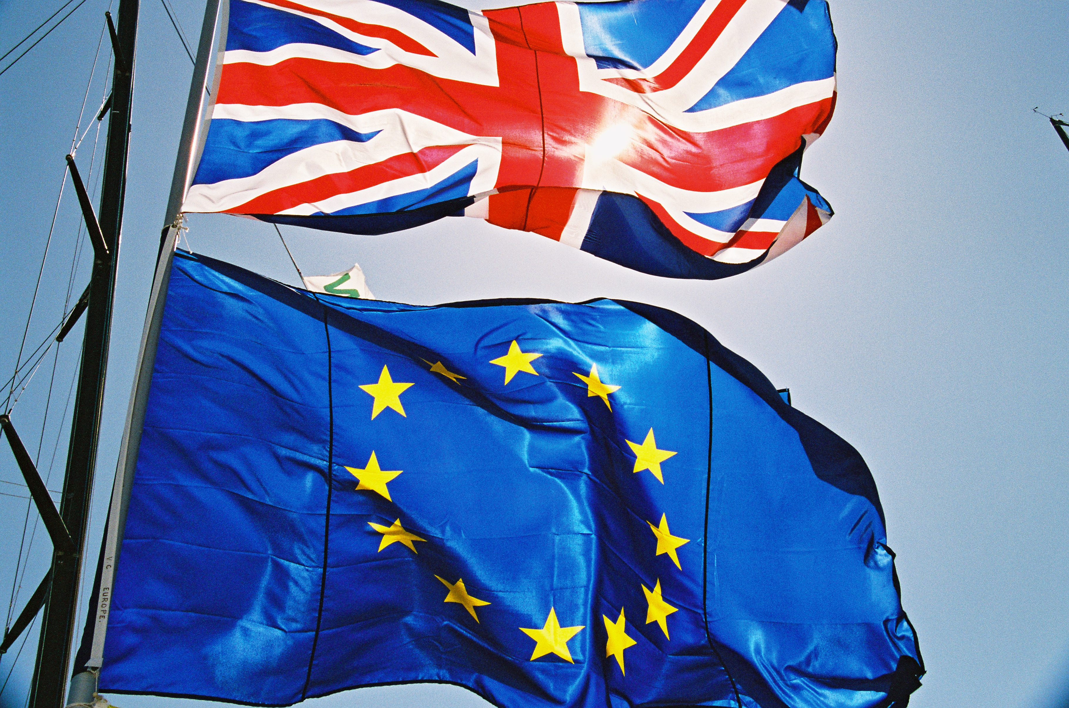 Flaga Wielkiej Brytanii i flaga Unii Europejskiej na tle błękitnego nieba