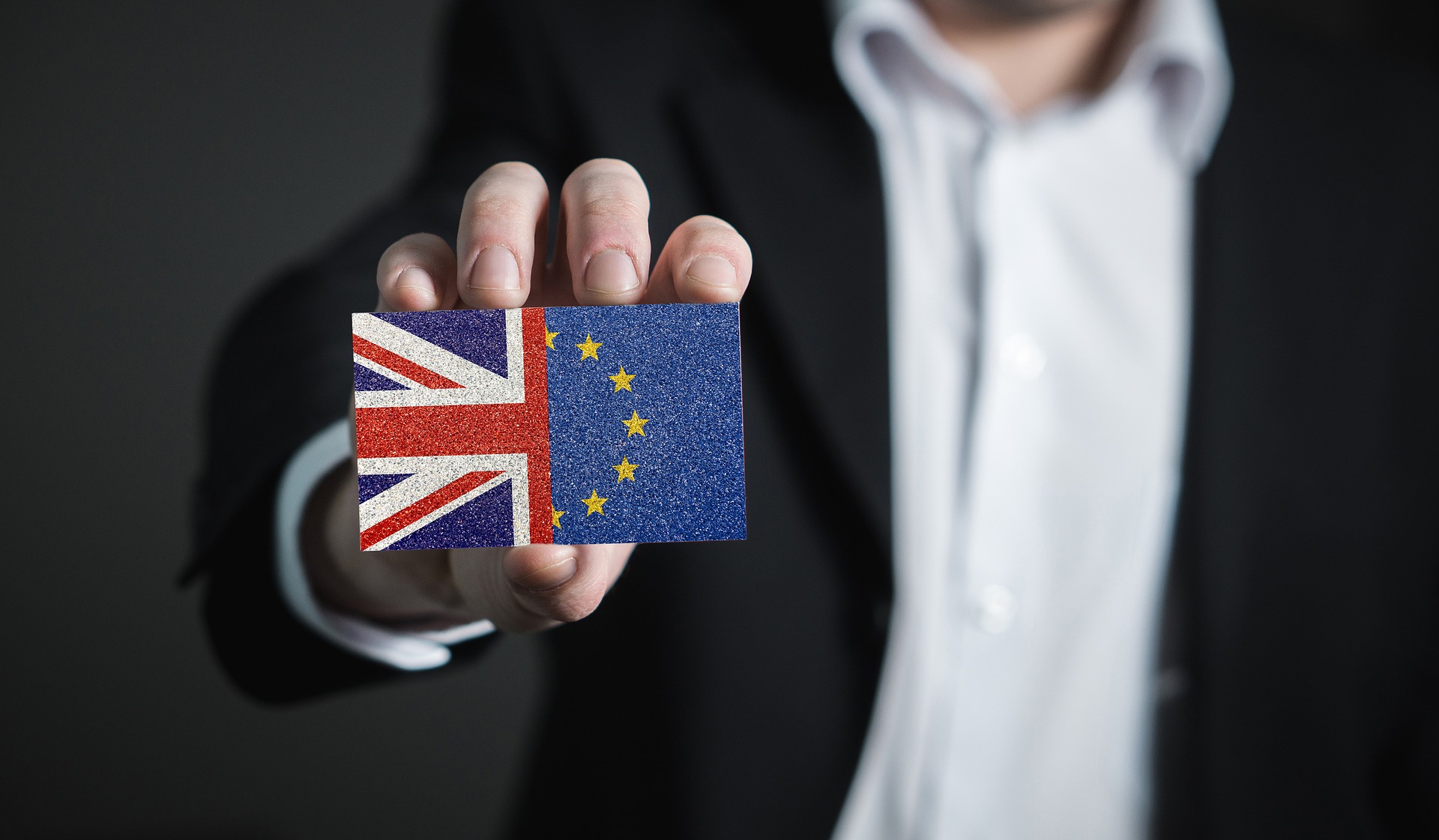 Mężczyzna trzyma w ręku kostkę złożoną z połówki flagi UK i UE